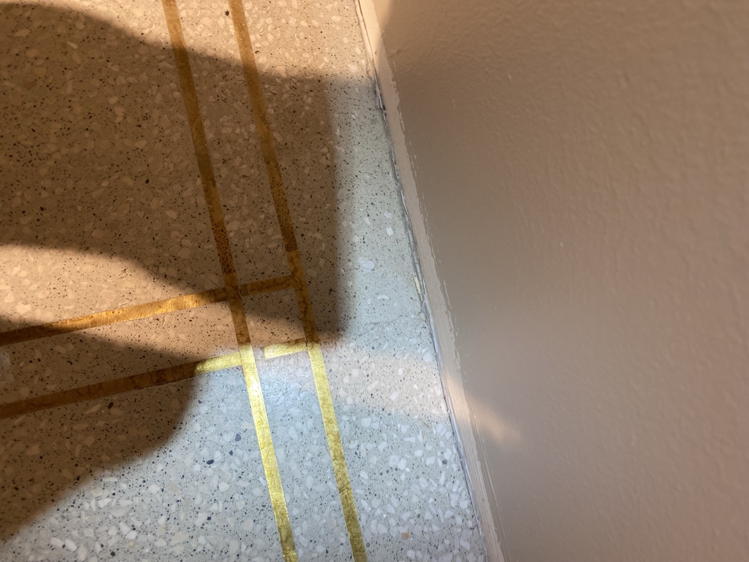 Terrazzo-põrandasse paigaldatud ristuvad messingliistud